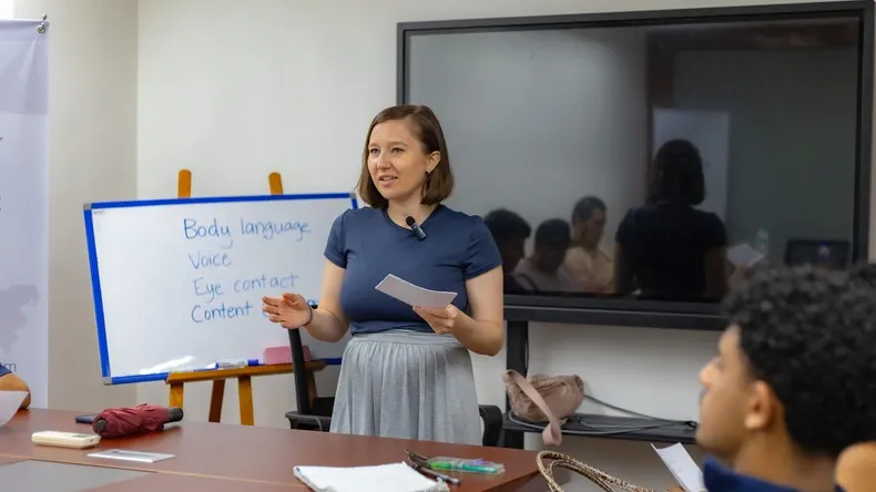 مدرسة لغة إنجليزية في معهد أوسم Awesome بماليزيا أثناء شرح المحاضِرة للطلاب داخل الصف